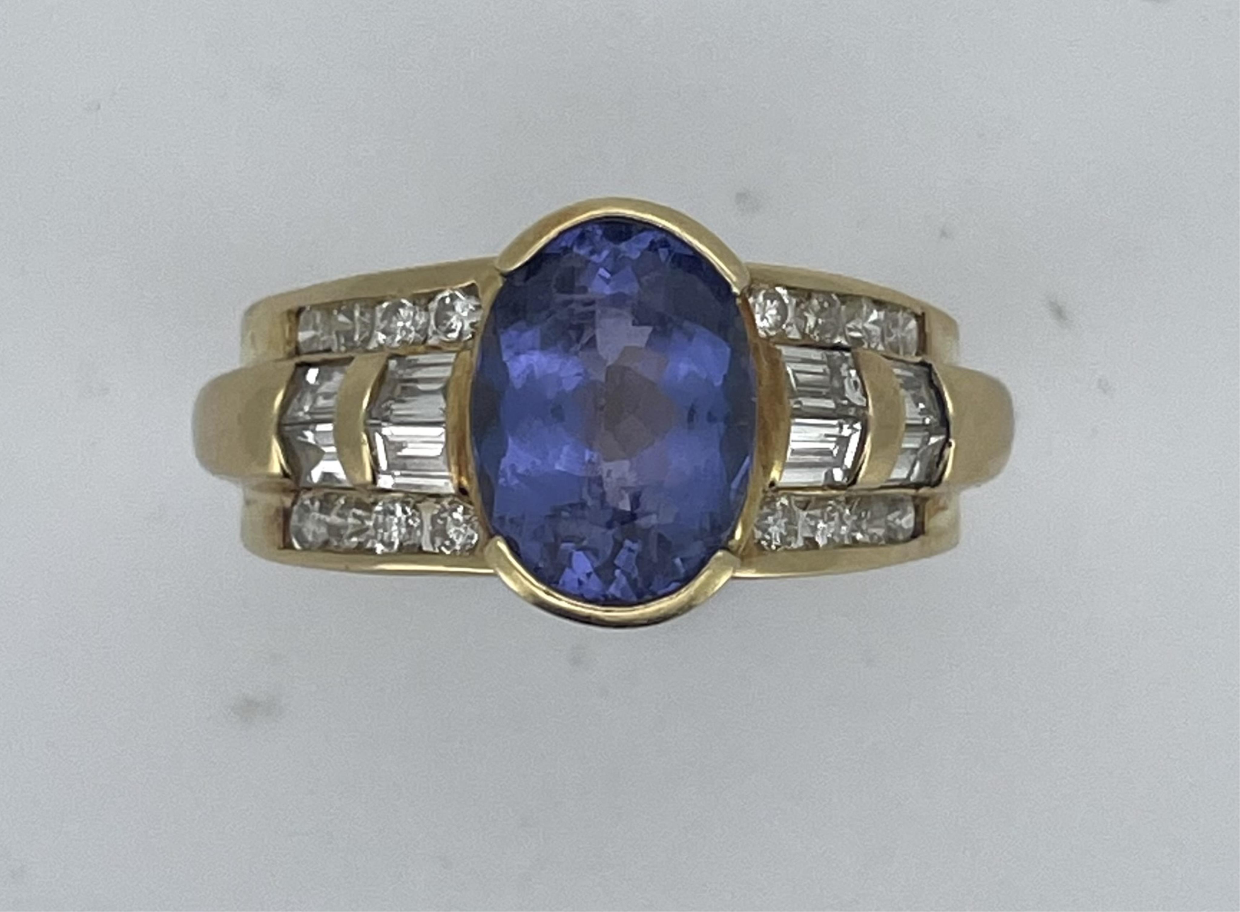 A tanzanite and diamond ring, set with an oval tanzanite measuring approximately 10.9 x 8.3 x 5.5mm, weighing approximately 3.00 carats, to a bombé band set with brilliant-cut and baguette diamonds totalling approximatel